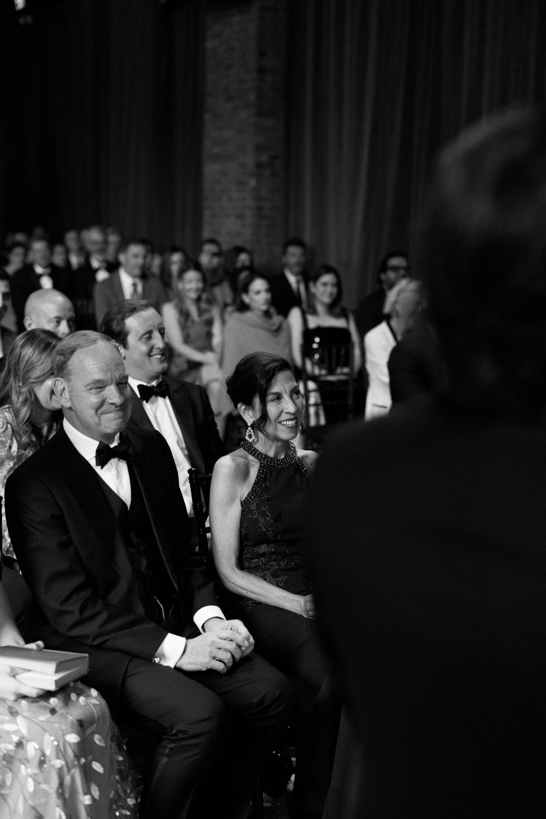 A stylish New York City wedding, rustic brick walls, velvet drapery, and golden candlelight, capturing the intimate, cinematic atmosphere of the iconic venue.
