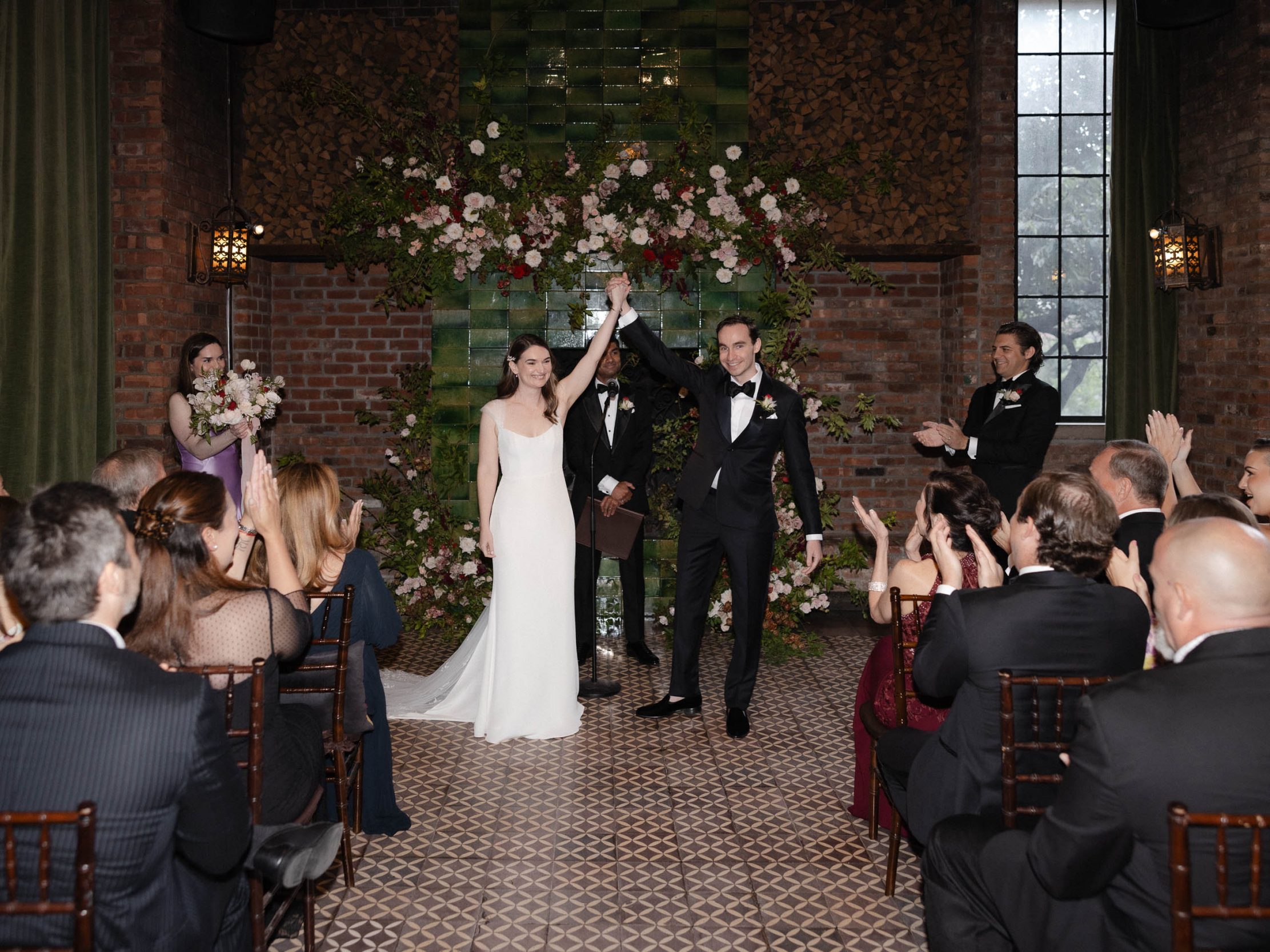 A stylish New York City wedding, rustic brick walls, velvet drapery, and golden candlelight, capturing the intimate, cinematic atmosphere of the iconic venue.