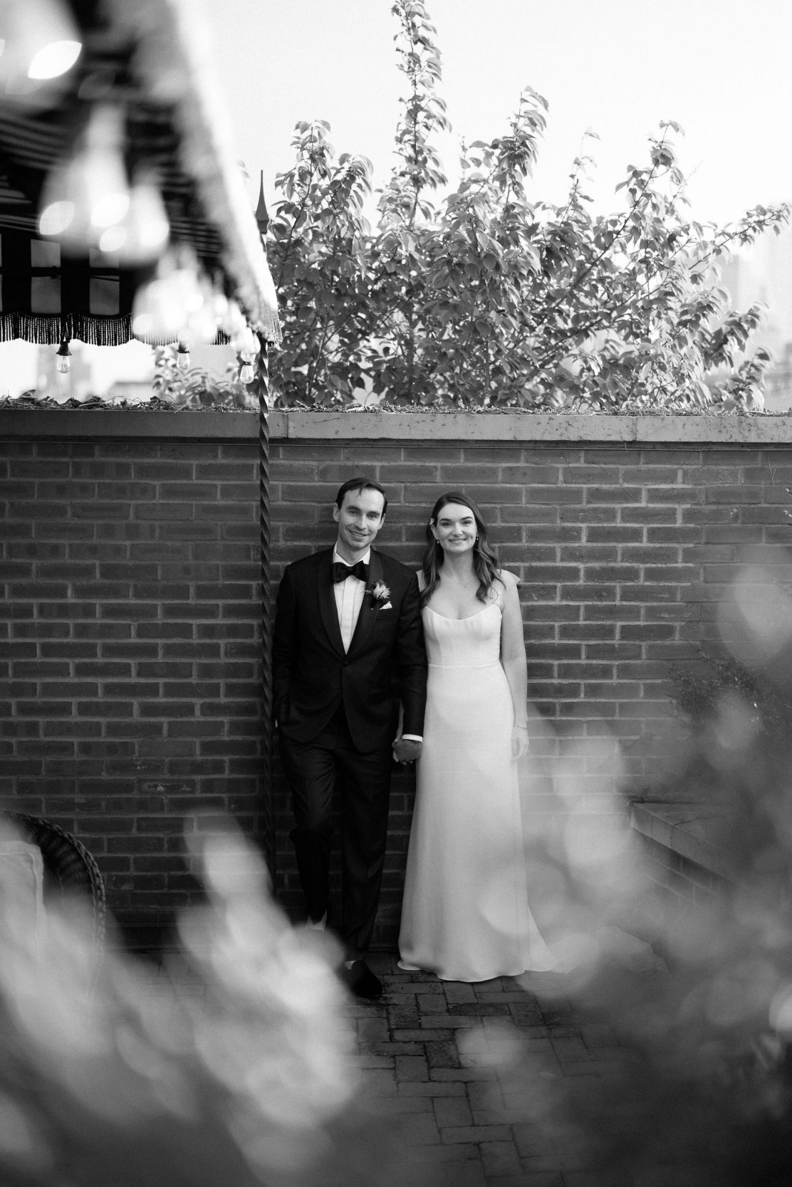 A stylish New York City wedding, rustic brick walls, velvet drapery, and golden candlelight, capturing the intimate, cinematic atmosphere of the iconic venue.