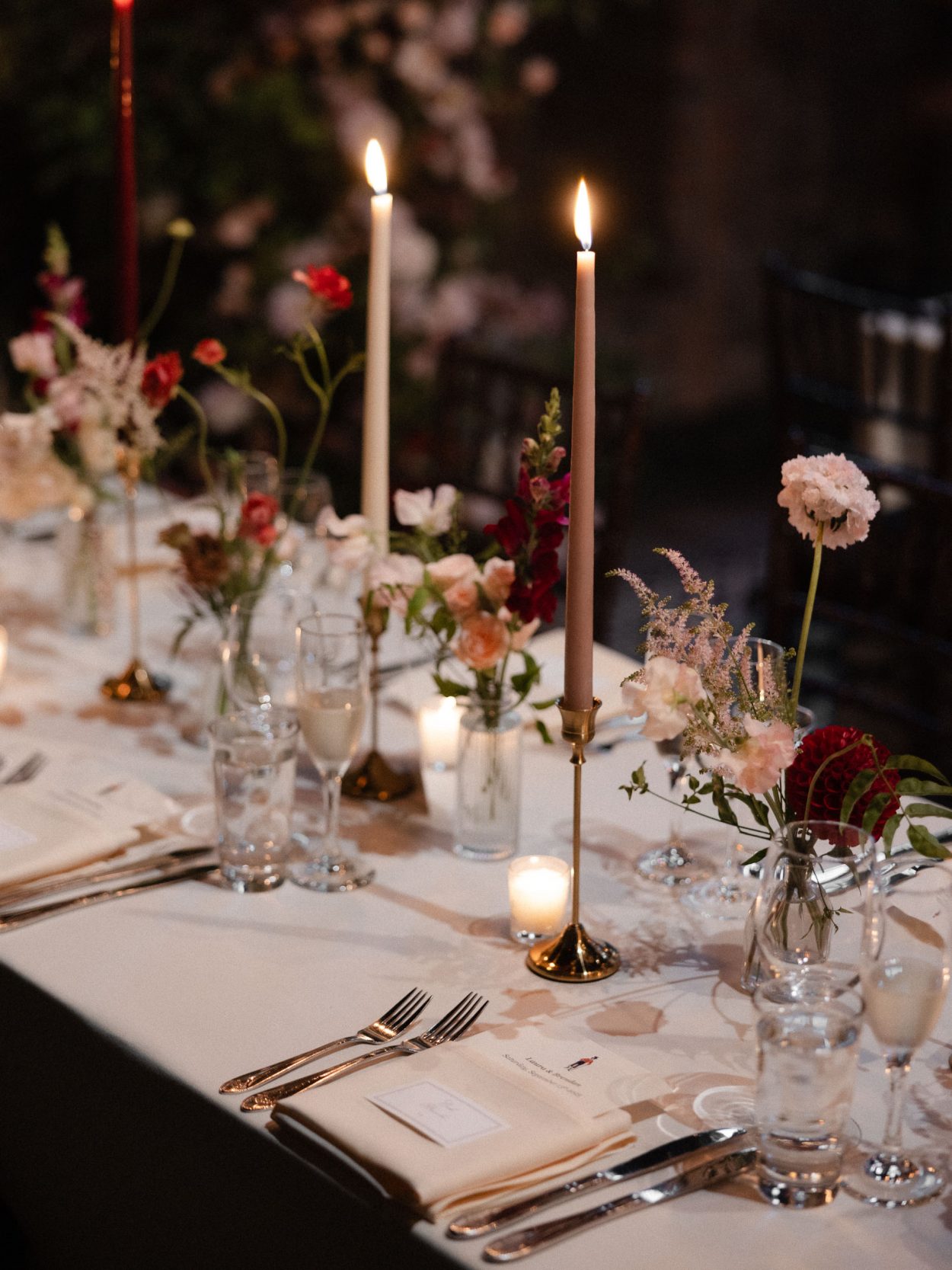 A stylish New York City wedding, rustic brick walls, velvet drapery, and golden candlelight, capturing the intimate, cinematic atmosphere of the iconic venue.