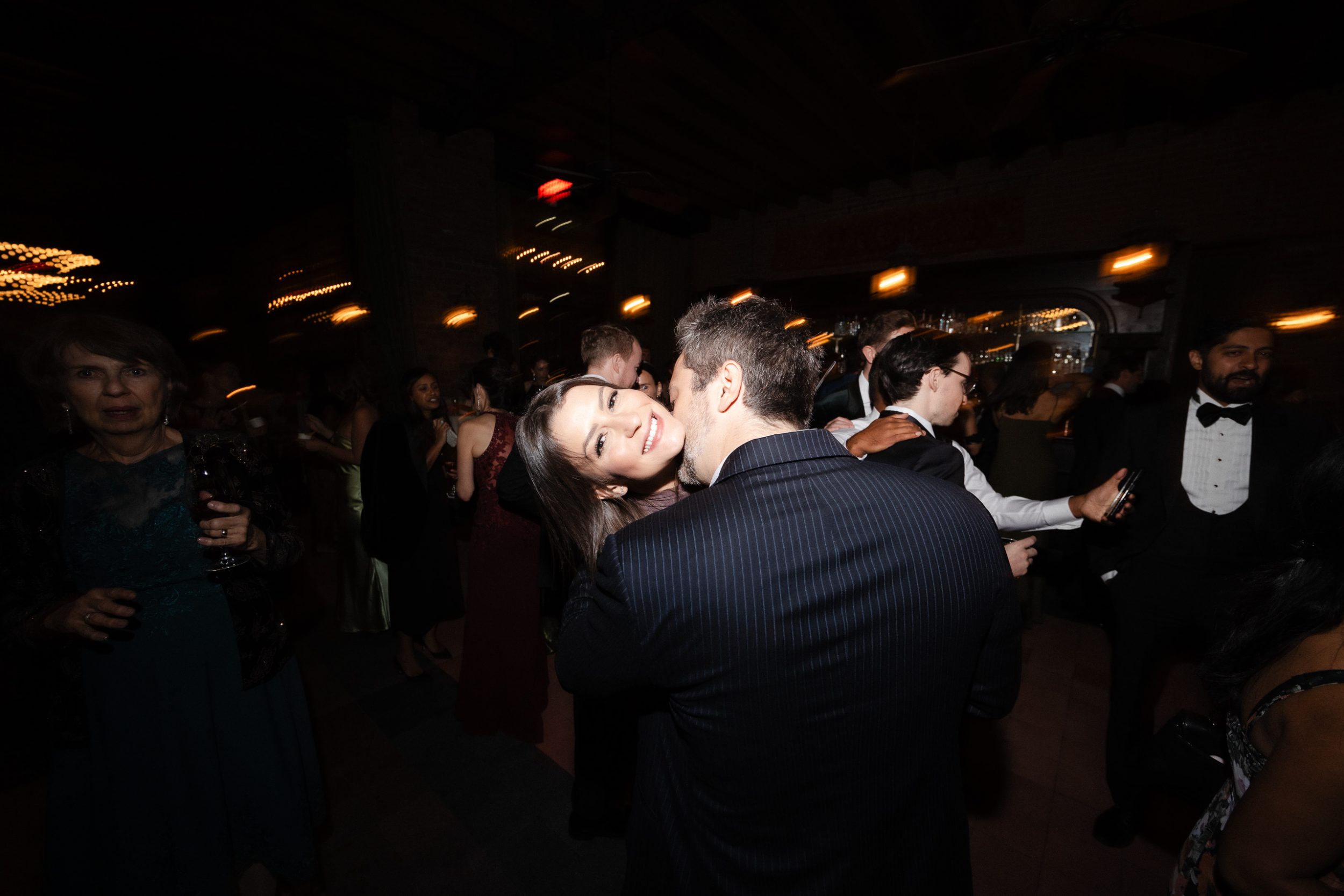 A stylish New York City wedding, rustic brick walls, velvet drapery, and golden candlelight, capturing the intimate, cinematic atmosphere of the iconic venue.