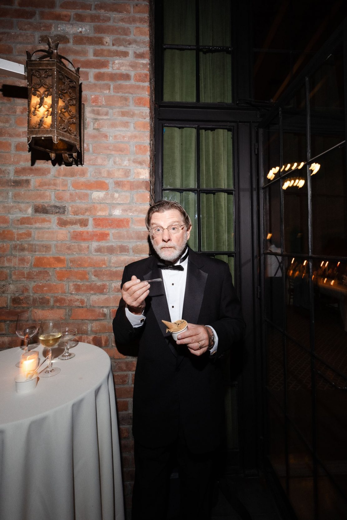 A stylish New York City wedding, rustic brick walls, velvet drapery, and golden candlelight, capturing the intimate, cinematic atmosphere of the iconic venue.